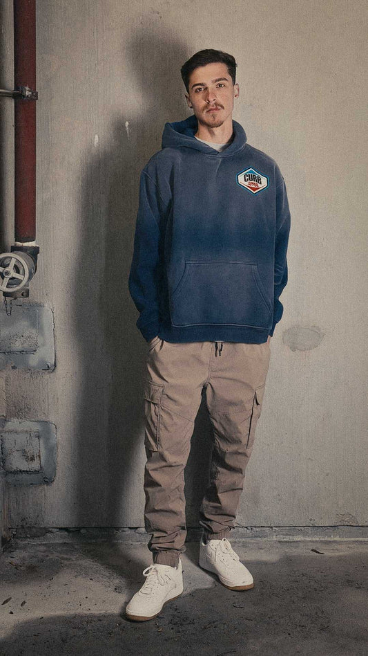Man wearing Pit Stop Hoodie in industrial setting.
