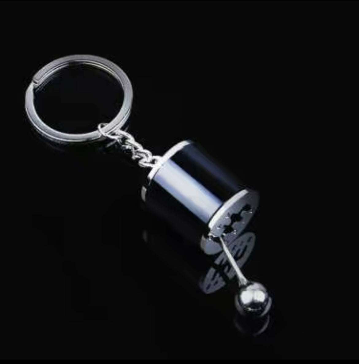 Shifter keychain with realistic mini gear design on black background.