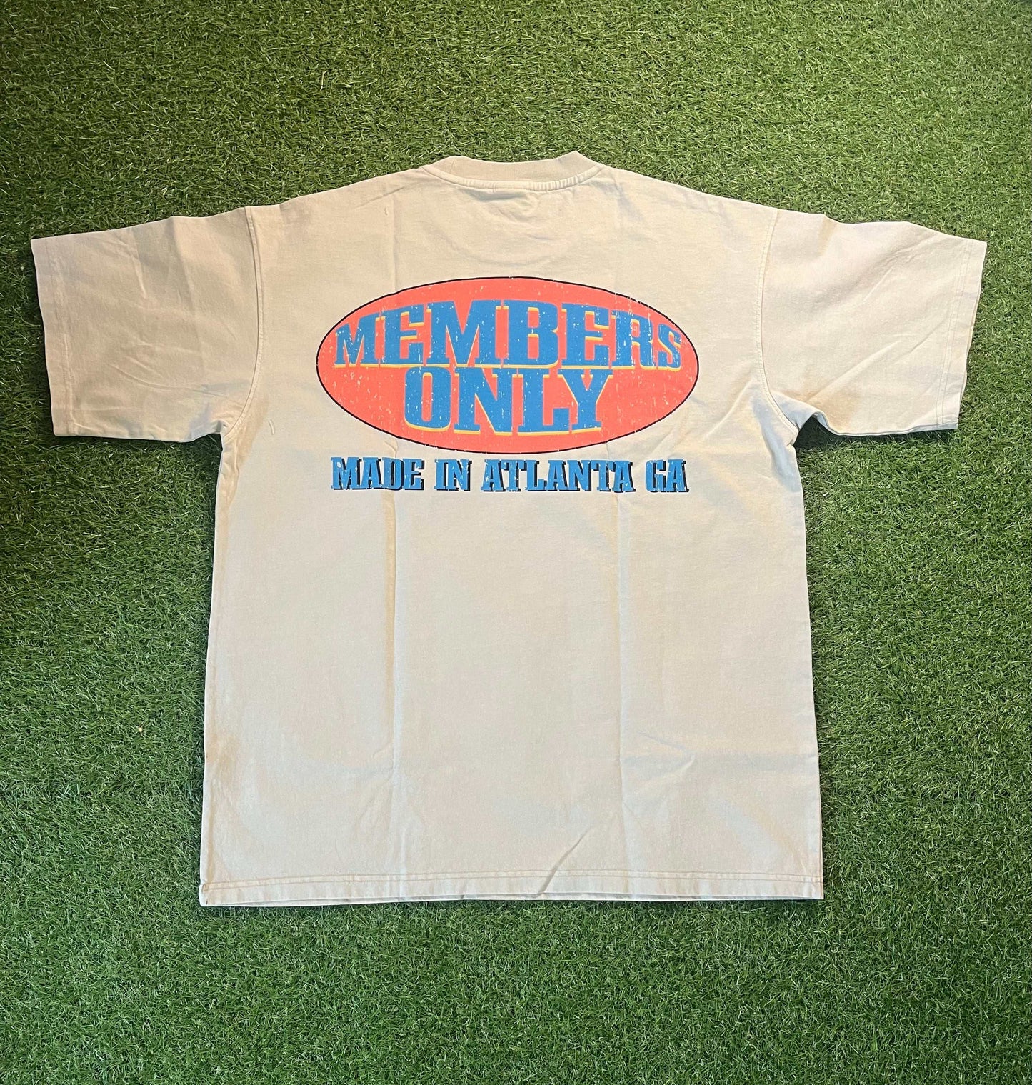 Members Only tee with bold graphics, designed in Atlanta, on a grassy background.