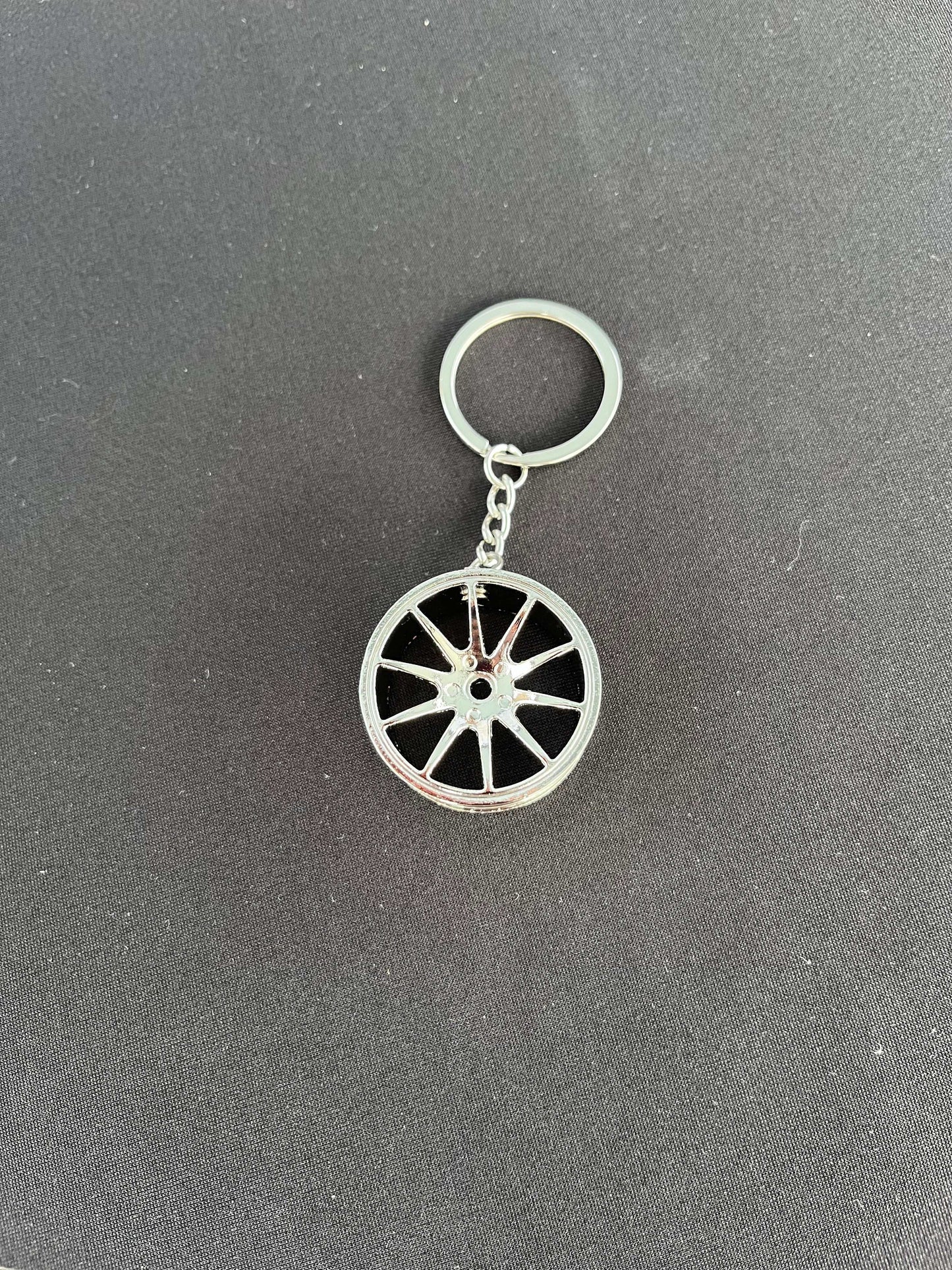 Wheel keychain with racing wheel design, available in black or chrome.