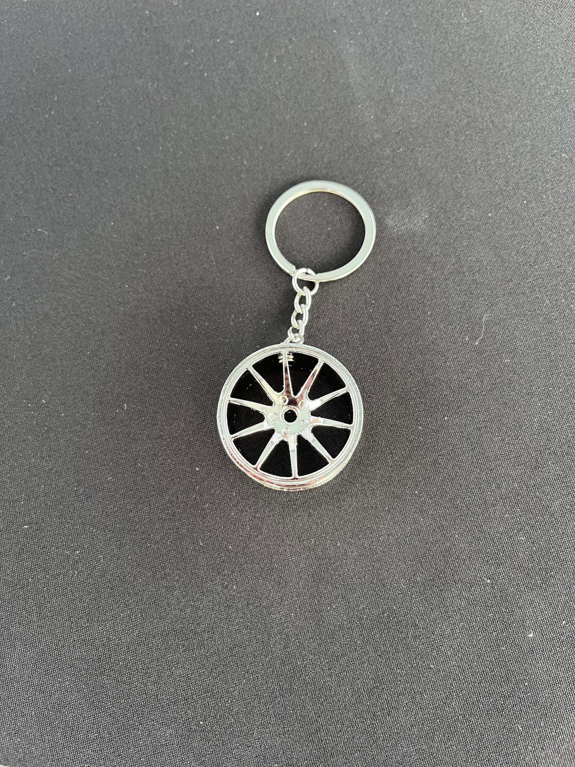 Wheel keychain with racing wheel design, available in black or chrome.
