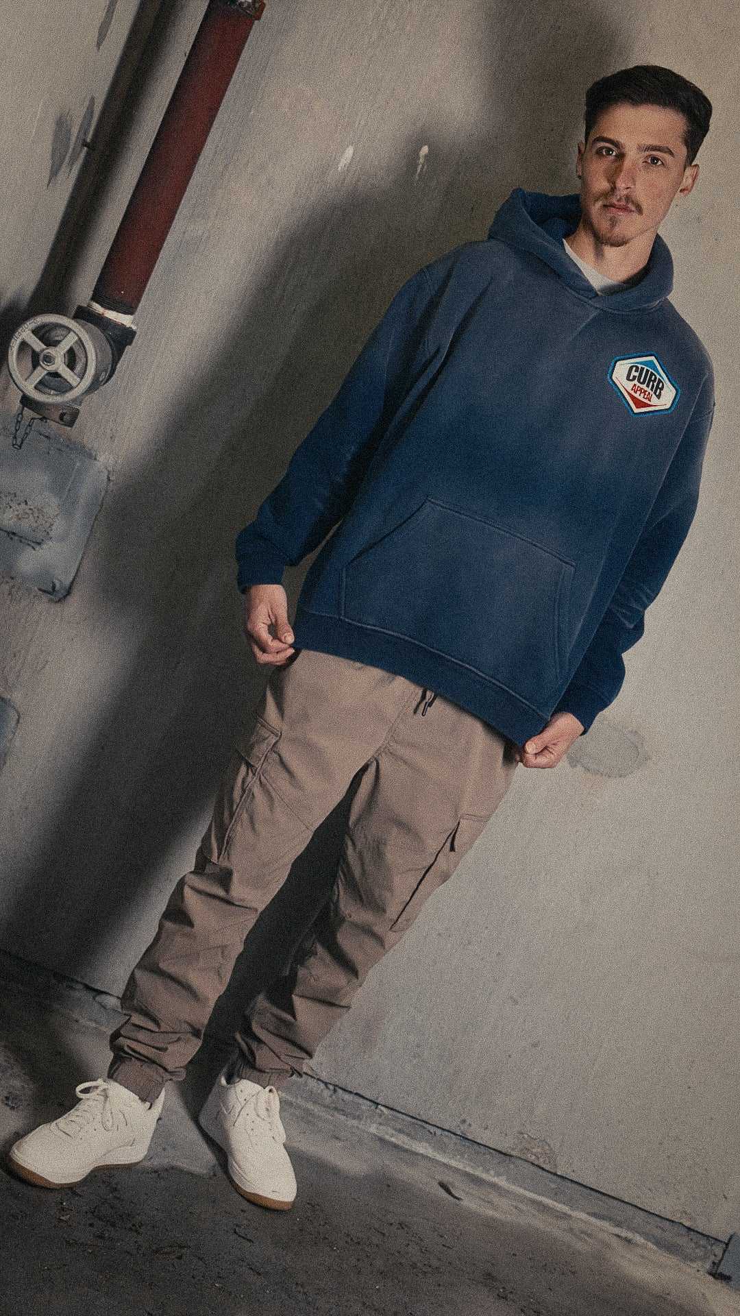 Man wearing Pit Stop Hoodie in a casual setting, showcasing its loose fit and heavyweight fleece material.