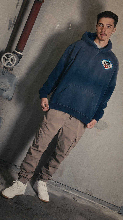 Man wearing Pit Stop Hoodie in a casual setting, showcasing its loose fit and heavyweight fleece material.