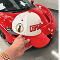 The Winner's Circle Hat with red suede bill and 3D stitching, inspired by racing culture.
