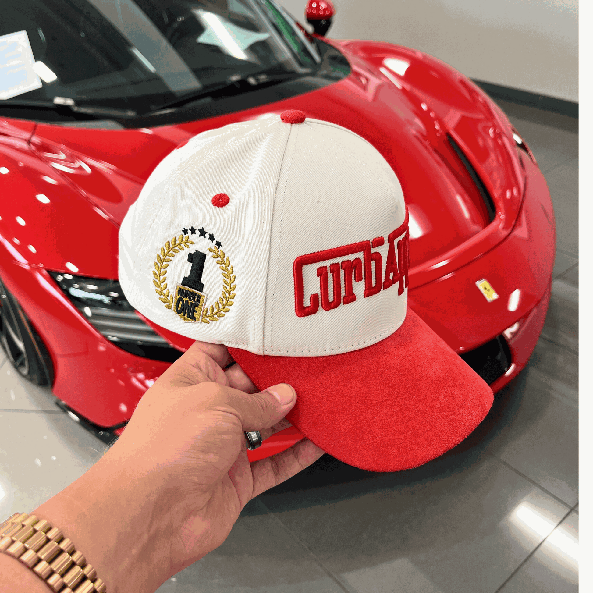 The Winner's Circle Hat with red suede bill and 3D stitching, inspired by racing culture.