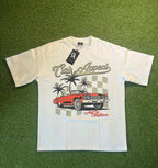 Donk Tee featuring a vibrant graphic design with a red car, palm trees, and an urban theme on a white T-shirt.