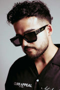 High Roller Shades worn by a person, featuring sleek black frames with gold detailing and dark lenses.