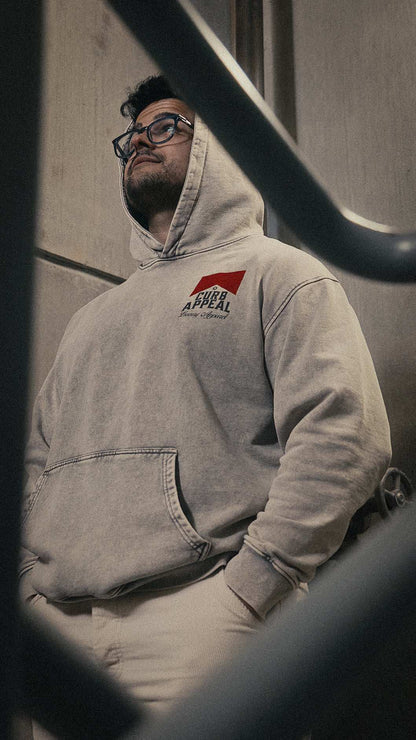 Vintage style acid wash hoodie worn by a person, featuring rib cuffs and hood, made of 100% cotton, unisex oversized model.