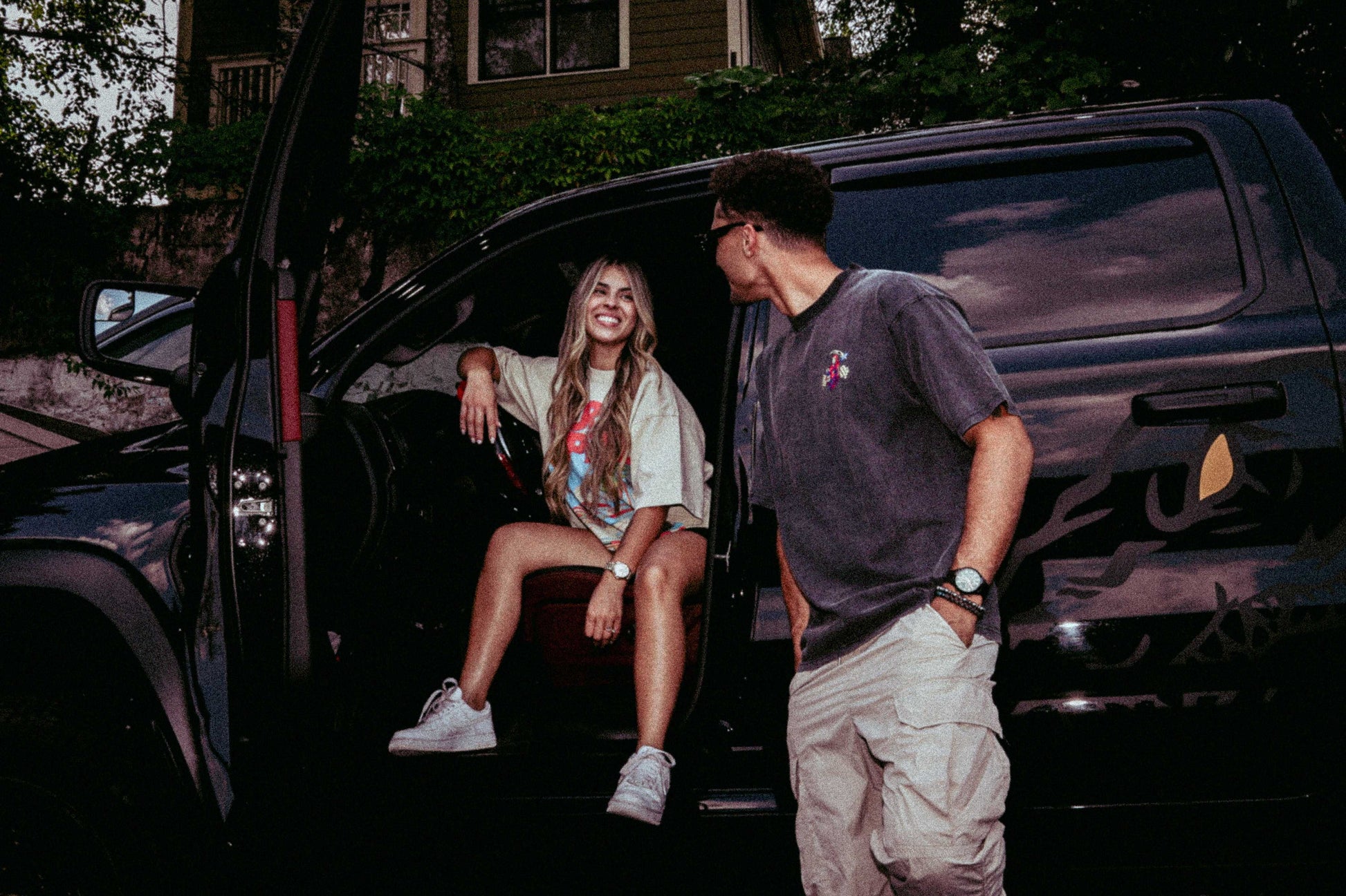 Two people wearing Widow Maker Tees, standing by a black SUV.