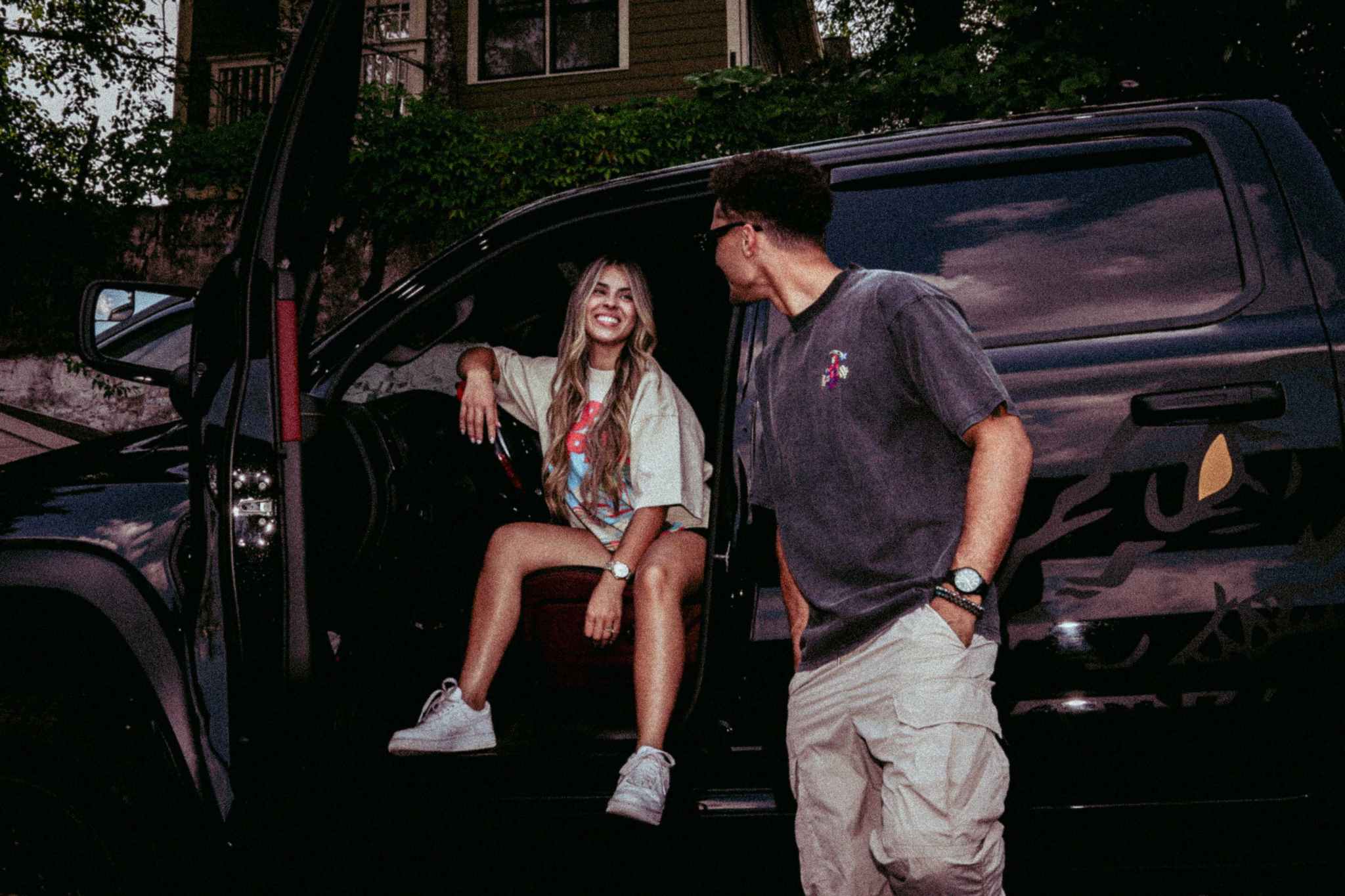 Two people wearing Widow Maker Tees, standing by a black SUV.