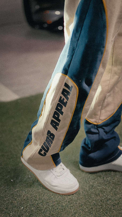 Motorsport Set joggers showcasing "Curb Appeal" text with a stylish design, paired with white sneakers.