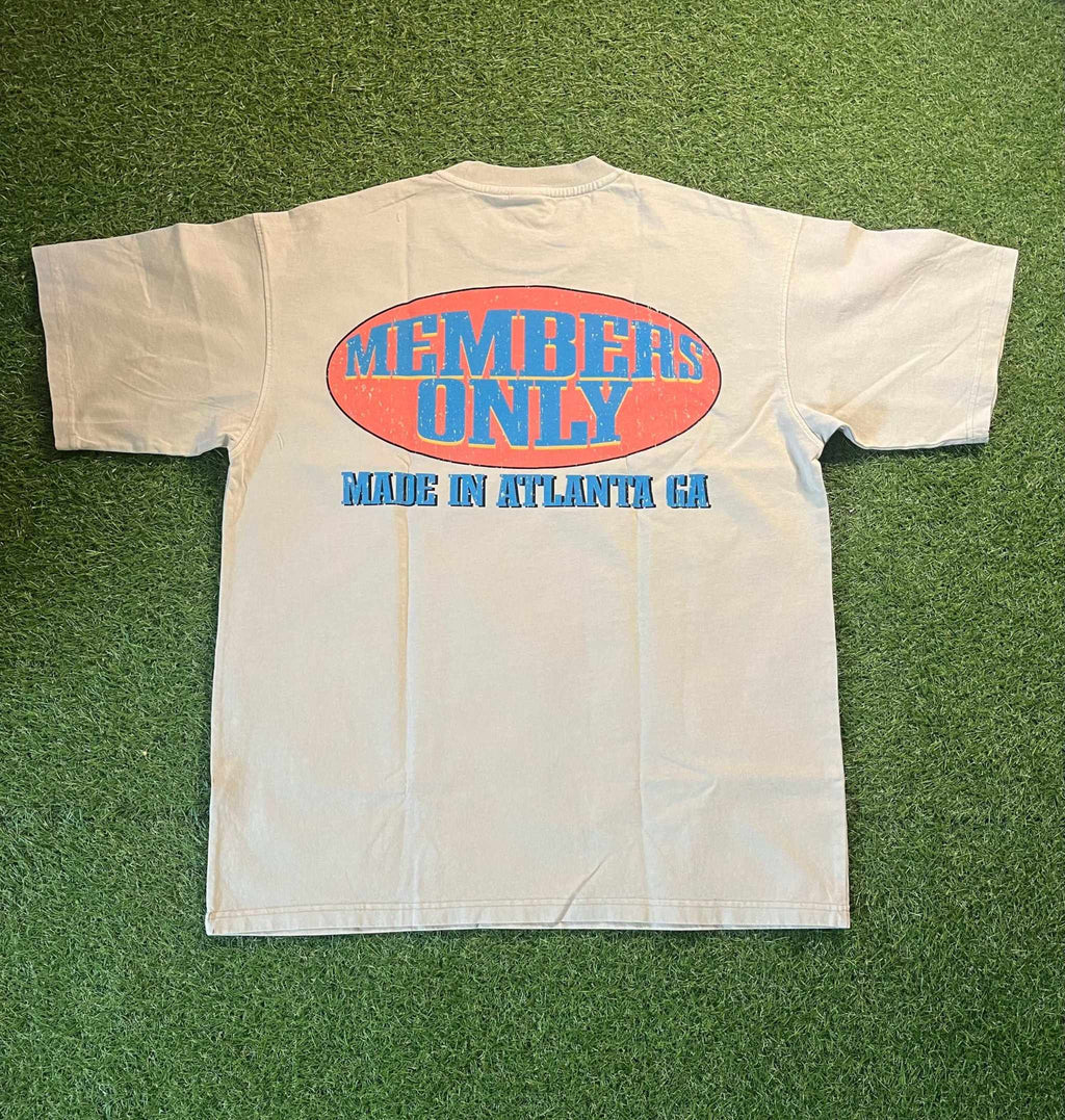 Members Only tee with bold graphics, designed in Atlanta, on a grassy background.
