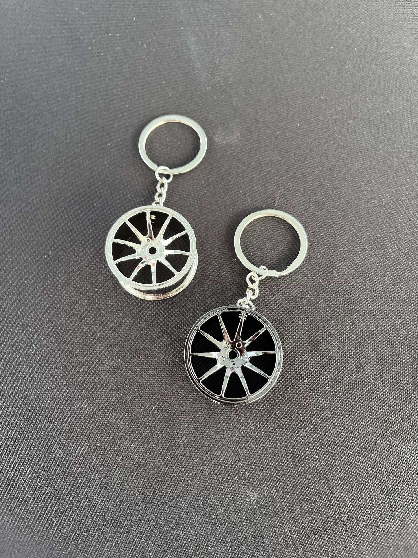Wheel keychain with car rim design on a black background.