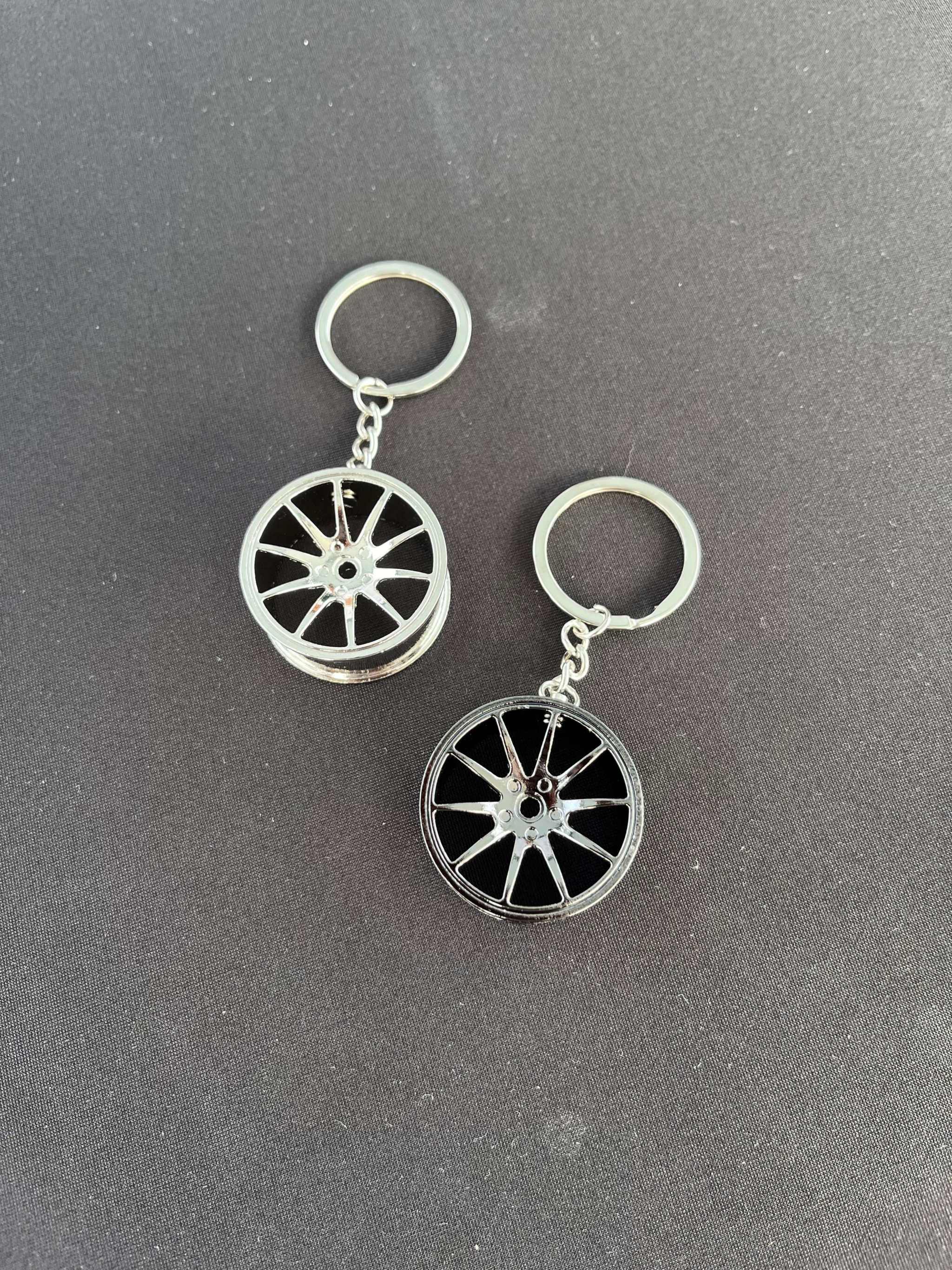 Wheel keychain with car rim design on a black background.