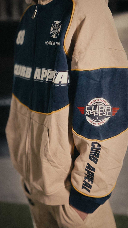 Motorsport track suit with zip-up hoodie and matching joggers, featuring logo patches and a relaxed silhouette.