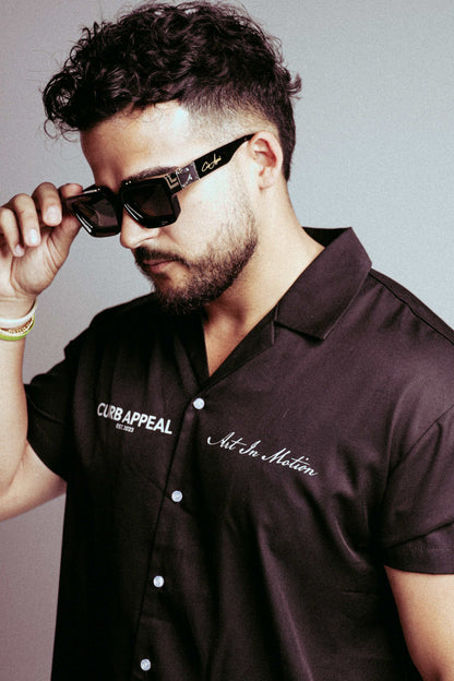 Lightweight black button-up shirt with lapel collar and street-inspired design, labeled "Art In Motion."